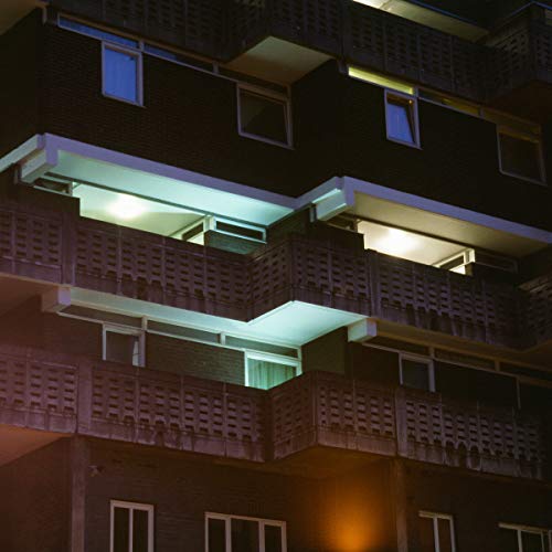 Night view of a multi-story brick building with illuminated balconies.
