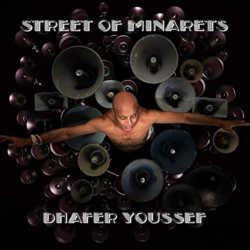 Album cover featuring a man with arms outstretched surrounded by numerous dark horn speakers.