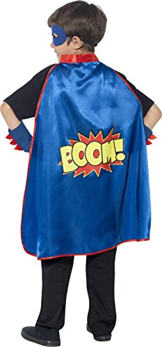 A young boy wearing a blue superhero cape, mask, and cuffs, standing with fists raised.