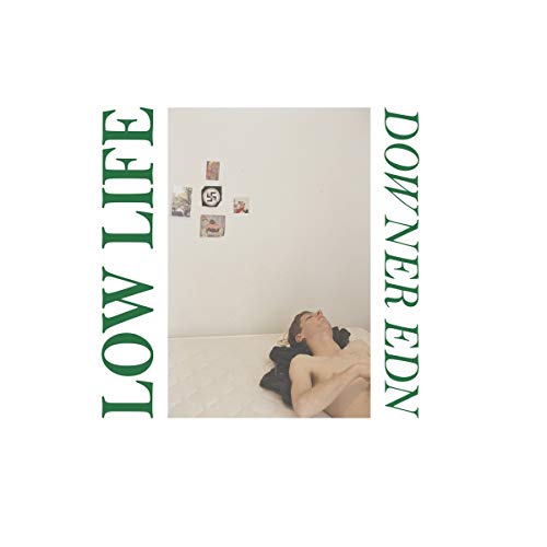 CD cover: a person lying on a bed with artwork on the wall.