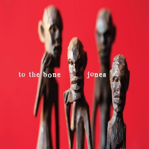 "Four wooden statues with human-like faces against a red background, with 'to the bone jones' text."