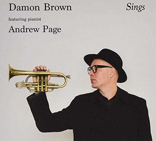 Man in black hat and coat holding a trumpet, album cover.