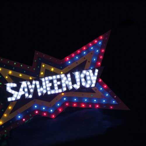 Illuminated star-shaped sign spelling "SAYWEENJOY" with colorful lights.
