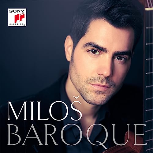 Portrait of guitarist Miloš Karadaglić with a guitar neck visible against a dark background.