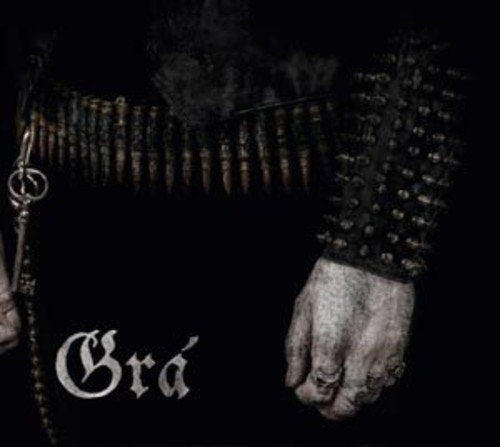 A pale hand with rings, a spiked wristband, and a bullet belt on black.