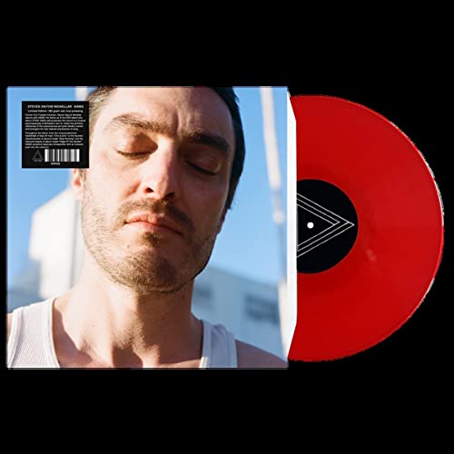 Vinyl record with red disc and album cover featuring a man’s portrait.