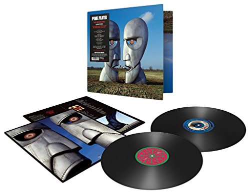 "Two large, gray, metallic heads facing each other in a field."