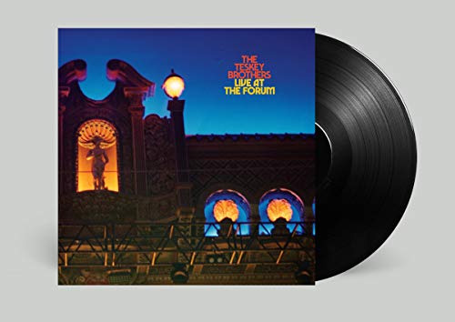 Vinyl record with album cover featuring a building facade at dusk.