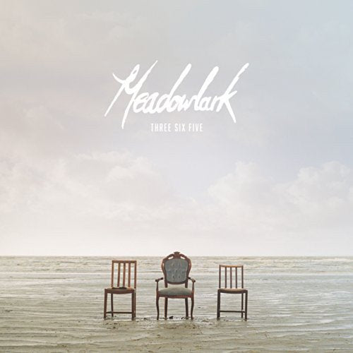The image depicts a vinyl record cover. #### Alt Text: "Three wooden chairs on a beach with 'Meadowlark' text above."