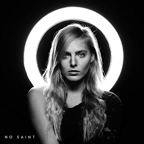 Black and white portrait of a woman standing in front of a circular light.