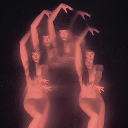 Blurred, red-toned image of three figures with raised arms.