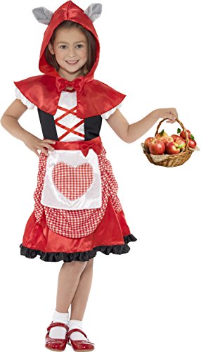 Young girl dressed as Little Red Riding Hood, holding a basket of apples, smiling.