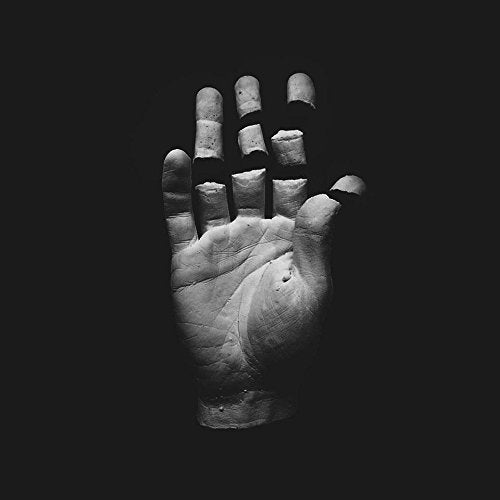 The alt text for the image is: "Close-up of a stone or clay sculpture against a black background."