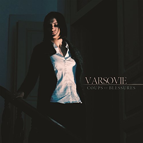 Woman in dark clothing stands on stairs, album title "VARSOVIE" visible.