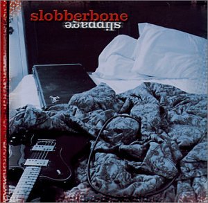"CD cover with a guitar on a bed, messy comforter, and amplifier."
