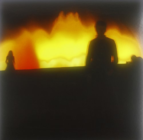Silhouettes of figures against a blurred, fiery orange and yellow background.