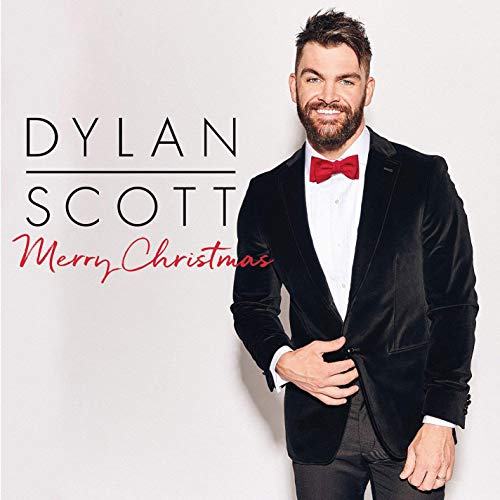 "Dylan Scott's 'Merry Christmas' CD cover featuring the artist in a tuxedo."