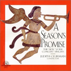 The image depicts a CD case for "A Season's Promise" by The New York Concert Singers. The cover art features an angel playing a trumpet, with the title and artist name prominently displayed. * **CD Case:** * The CD case is the main object in the image. * It is placed on a white surface, likely a table or countertop. * **Cover Art:** * The cover art features an angel playing a trumpet. *