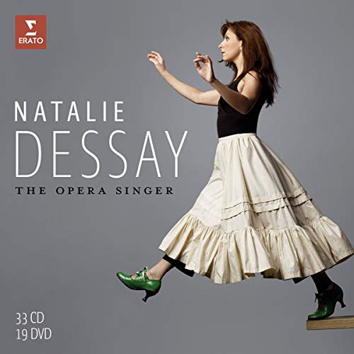 Natalie Dessay in a black top and tiered skirt, mid-stride.