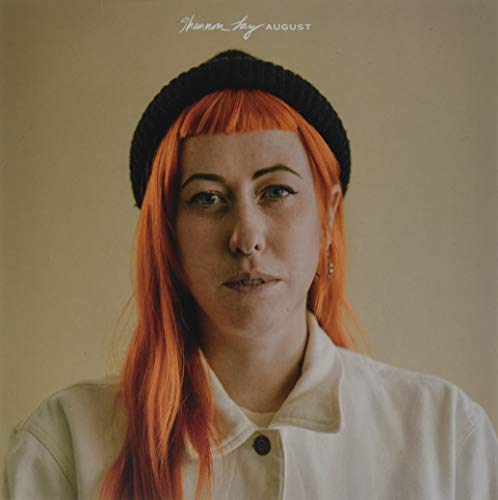 Portrait of a woman with orange hair wearing a black beanie.