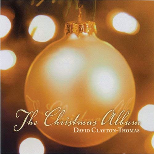 "Golden Christmas ornament with text 'The Christmas Album David Clayton-Thomas' on blurred lights background."