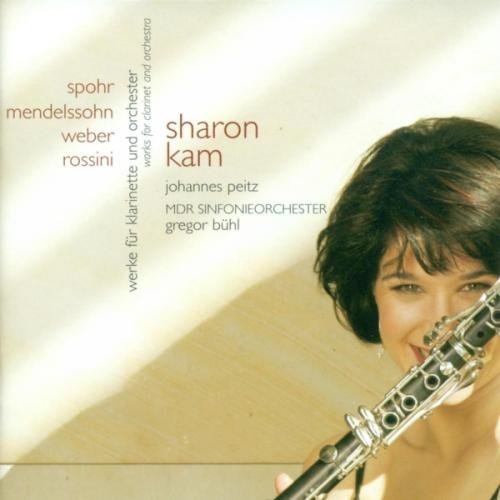 CD cover with a woman holding a clarinet and smiling, against a beige background.