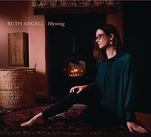 Ruth Angell album cover: woman seated near a lit fireplace.