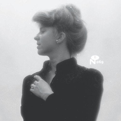 Black and white profile portrait of Joanna Brouk against a hazy, out-of-focus background.