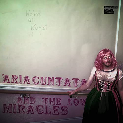 Person with pink hair leaning on railing with album title text.
