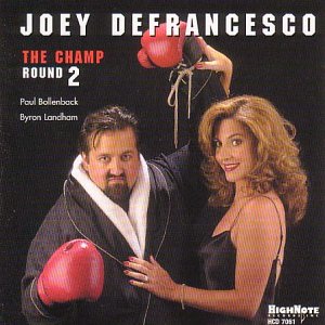 CD album cover: man in robe and boxing gloves with woman in black dress.
