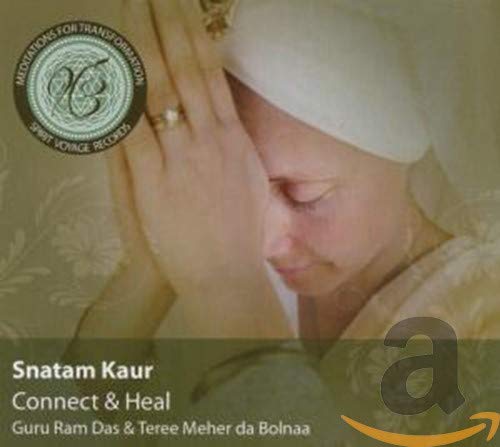 Snatam Kaur with hands in prayer position wearing a white head covering.