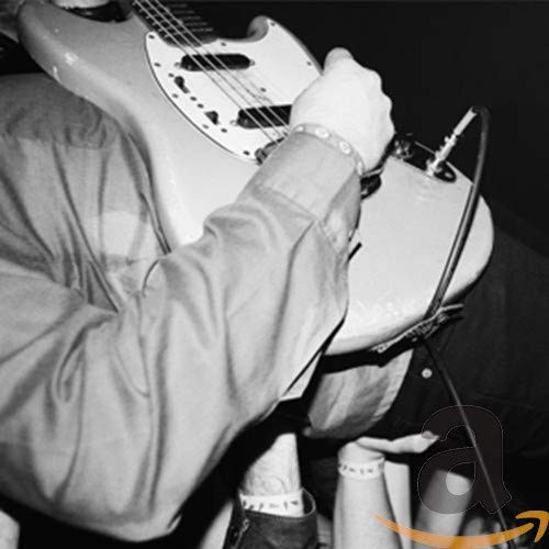 Black and white photo of a musician playing a white electric guitar.