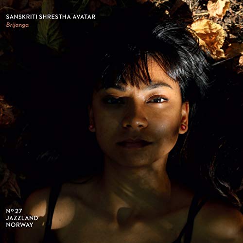 "Album cover featuring a woman with dark hair surrounded by leaves."