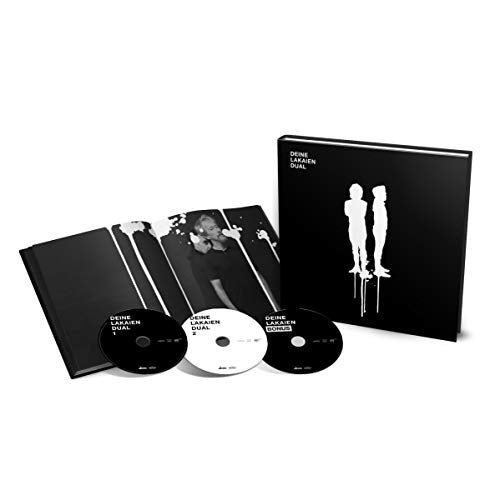 "Black hardcover book with white silhouettes and three CDs, partially opened booklet nearby."