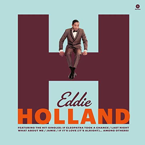 Man in brown suit sitting on large letter "E" on album cover.