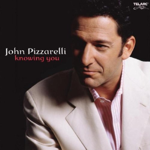 Album cover featuring a man in a white jacket against a dark background.