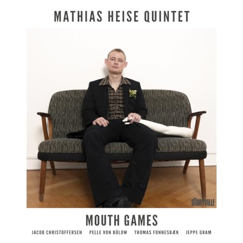 CD cover: Man in suit sits on patterned sofa, album title "Mouth Games".