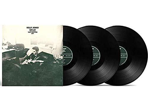 "Album cover with man on floor and three black vinyl records."