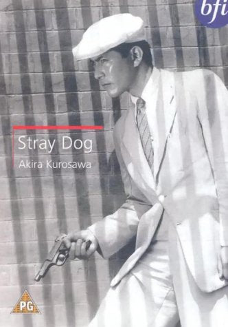 Black and white film still of a man in a suit holding a gun.