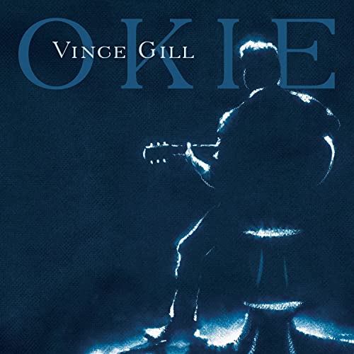 Vince Gill silhouette playing guitar on a stool against a dark blue background.
