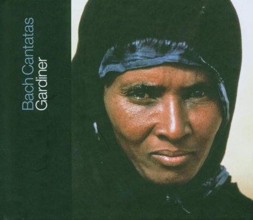 Close-up portrait of a person with a head covering, dark background.