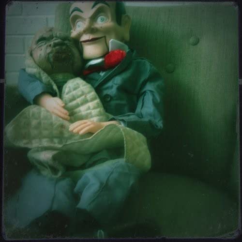 CD cover featuring ventriloquist dummies on a green sofa.