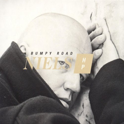 Close-up of a man’s face with album title “Bumpy Road” overlaid.