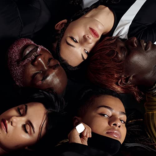 Close-up of five people with diverse skin tones lying head to head.