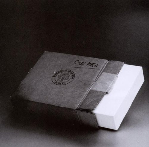 A sealed white box wrapped in dark envelope with "Confidential" stamp and logo.