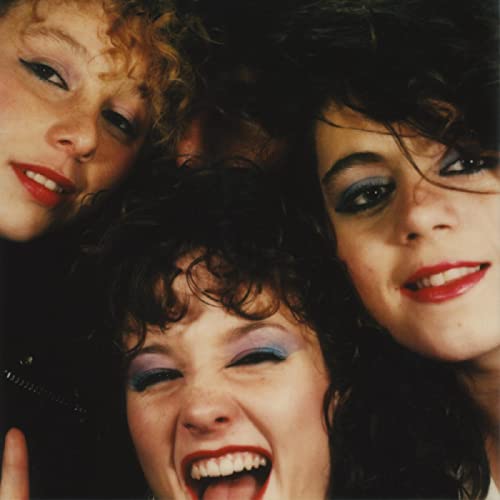 Close-up of three young women with bold eye makeup smiling.