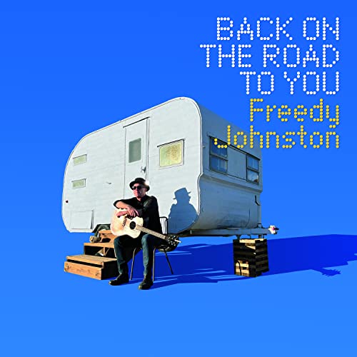 Album cover: Freedy Johnston sits with guitar before a vintage trailer.