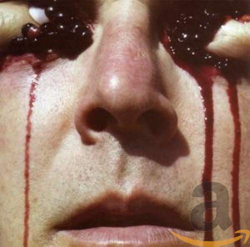 Close-up of a face with berries and red liquid streaming down.