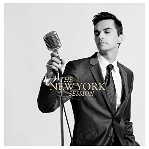 Man in a suit holding a vintage microphone, album cover art.