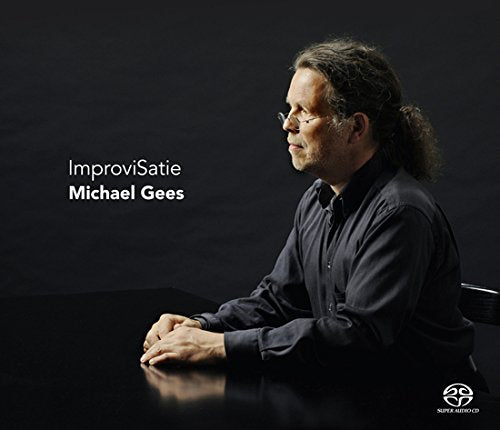 Man with long hair sits at table, looking left, on album cover.